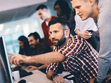 group millennials looking at a computer
