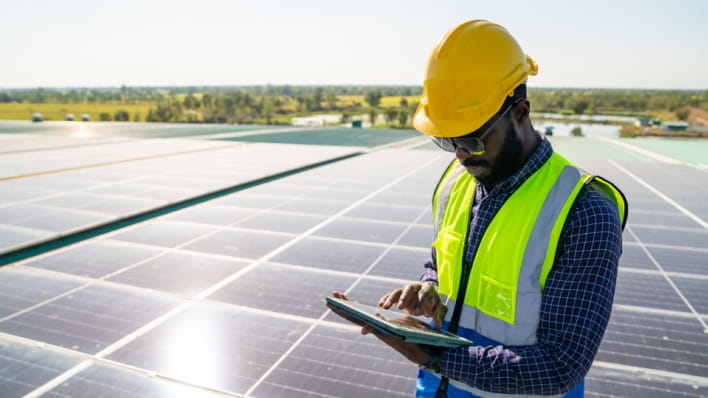 Solar farm engineer looks at tablet