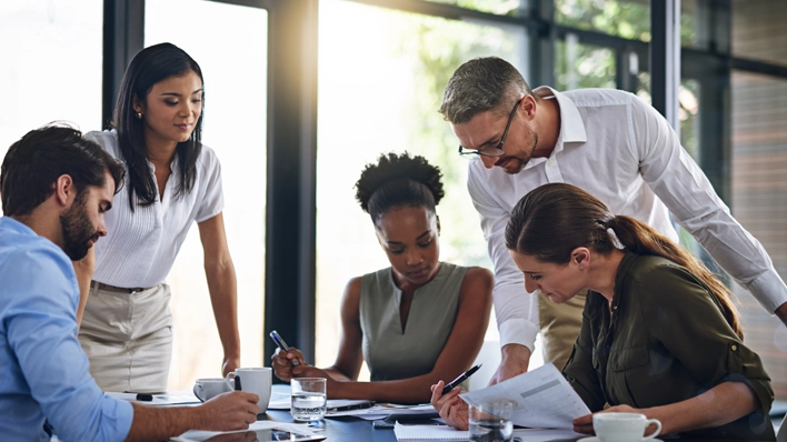 A team reviews MPact Advantage data at a conference table to strengthen their workforce strategy and planning.
