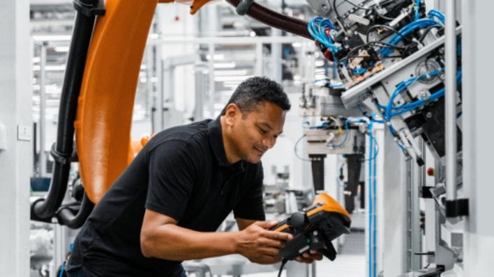 Engineer holding a controller managing automation.